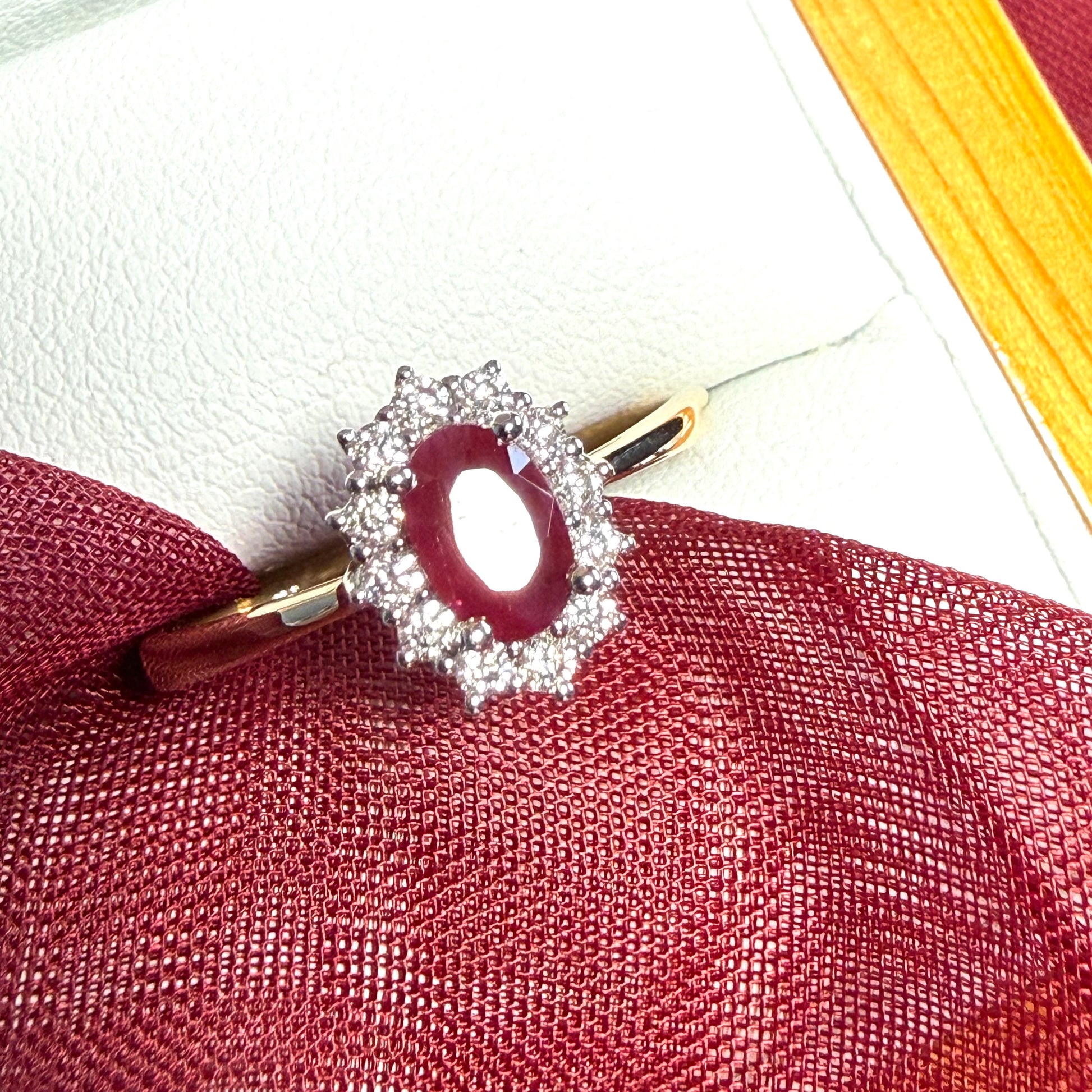 An oval red real ruby and diamond yellow gold cluster ring