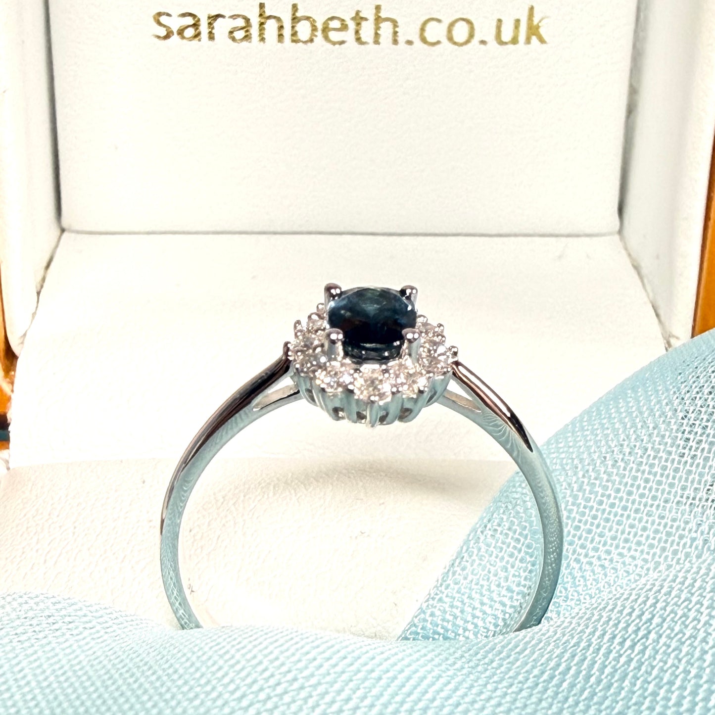 An oval shaped Blue Real Sapphire and Diamond White Gold Cluster Ring side view