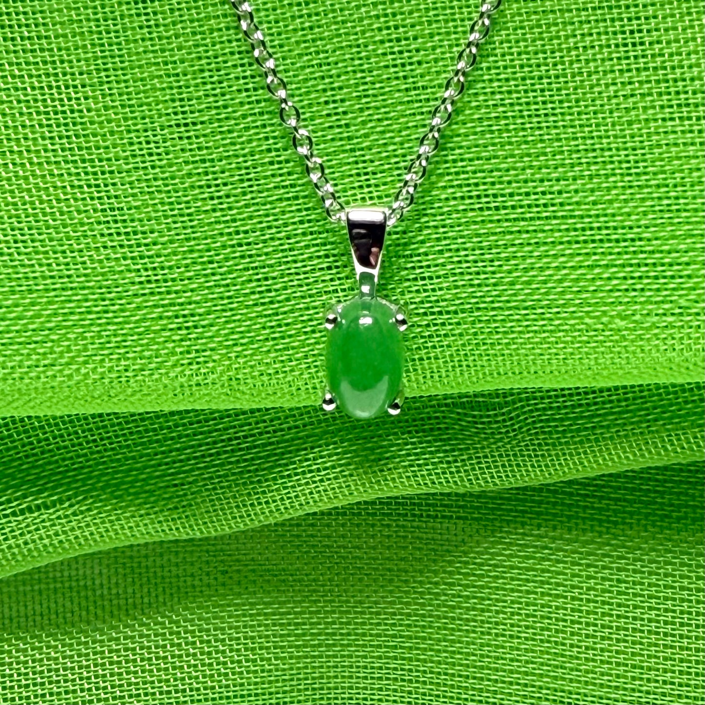 An oval shaped real green jade necklace white gold including chain