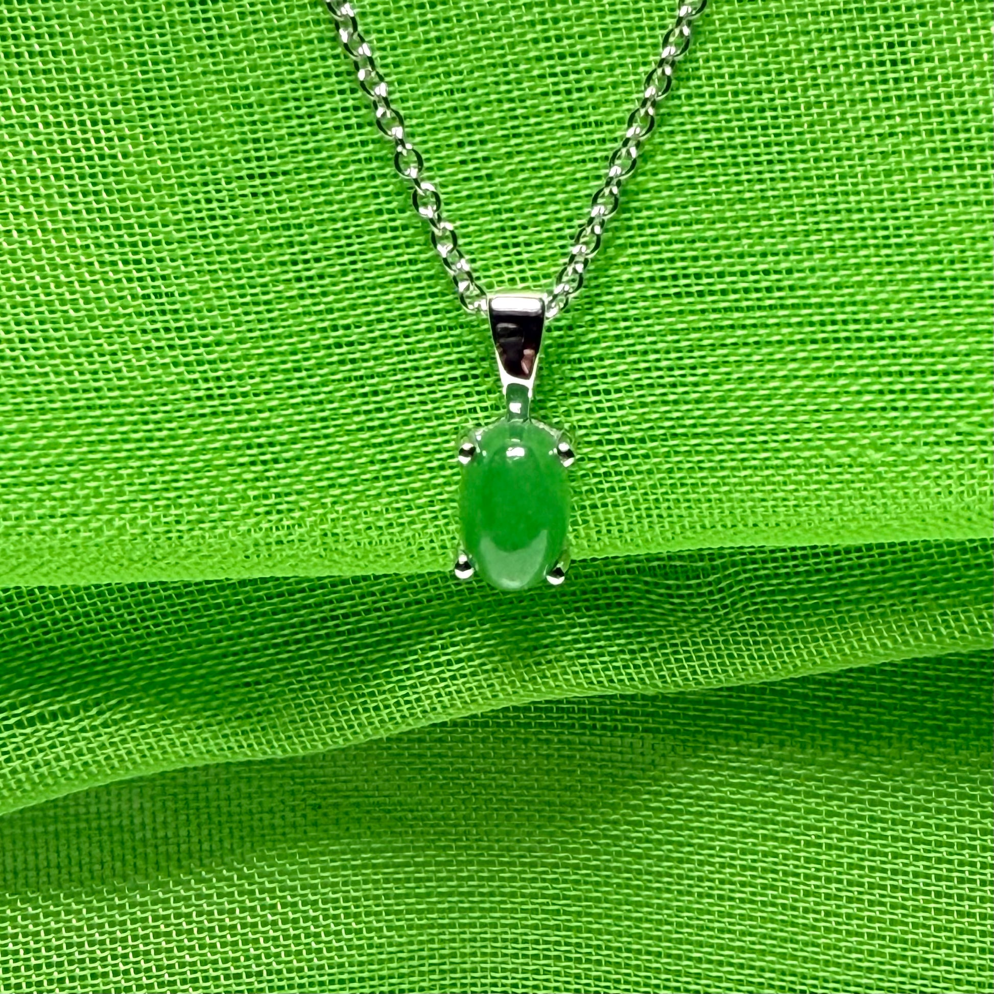 An oval shaped real green jade necklace white gold including chain