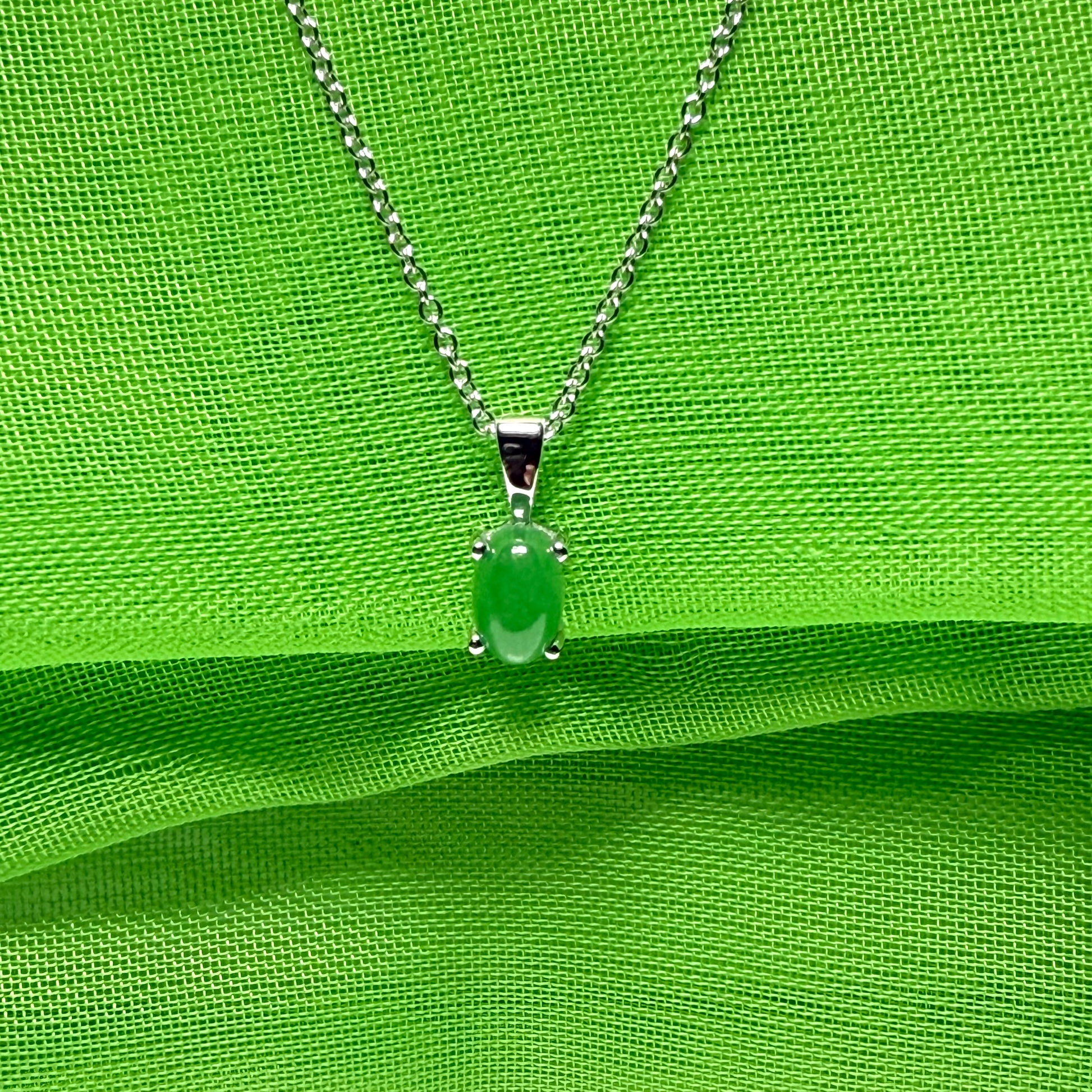An oval shaped real green jade necklace white gold including chain