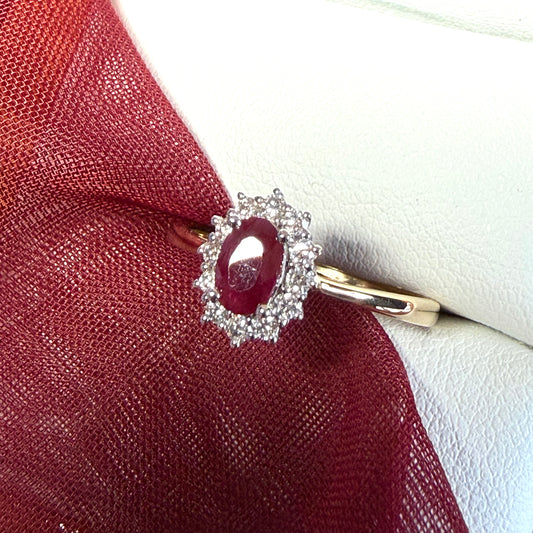 An oval red real ruby and diamond yellow gold cluster ring