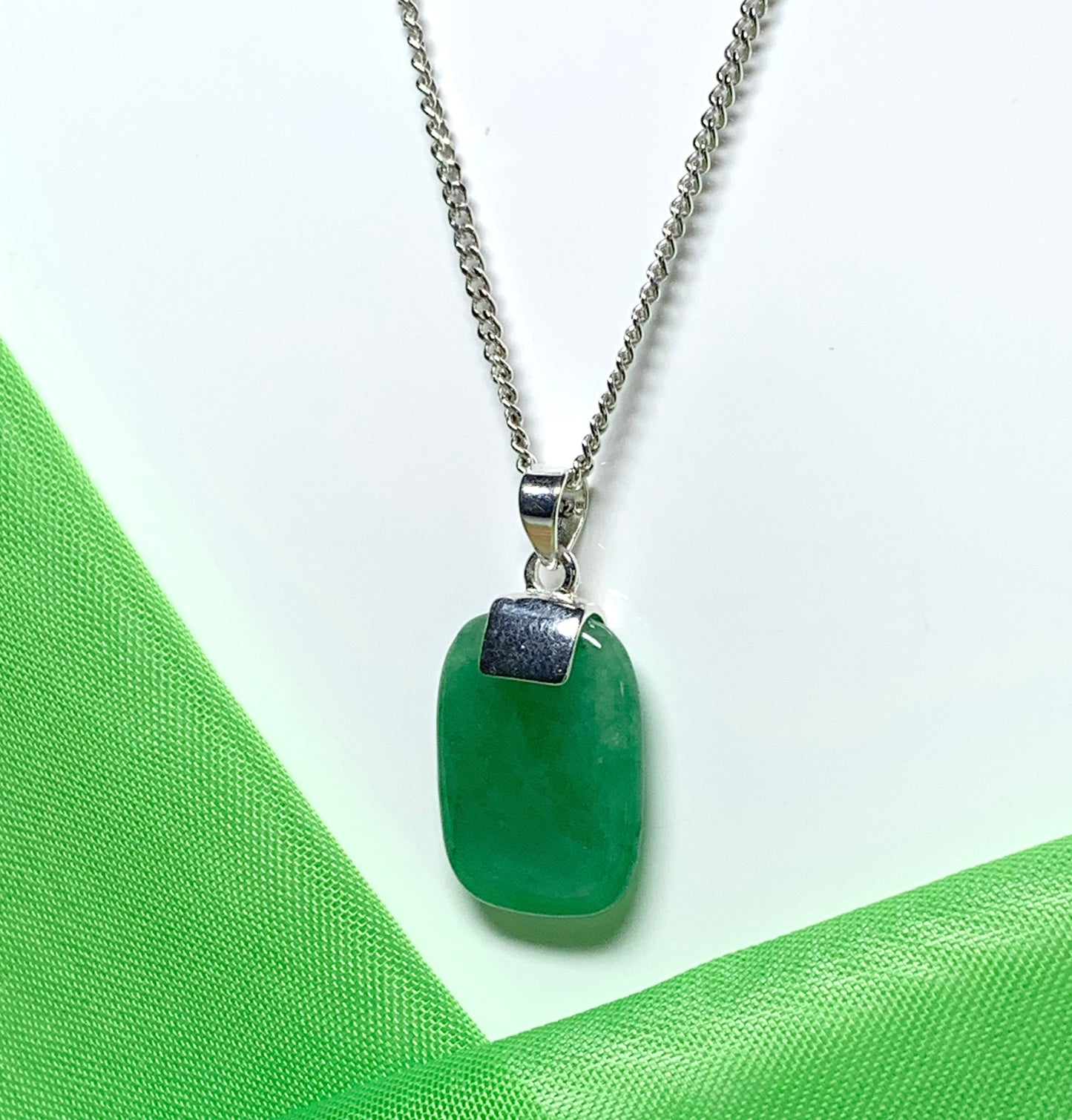 A necklace pendant having a real green jade sterling silver cushion shaped