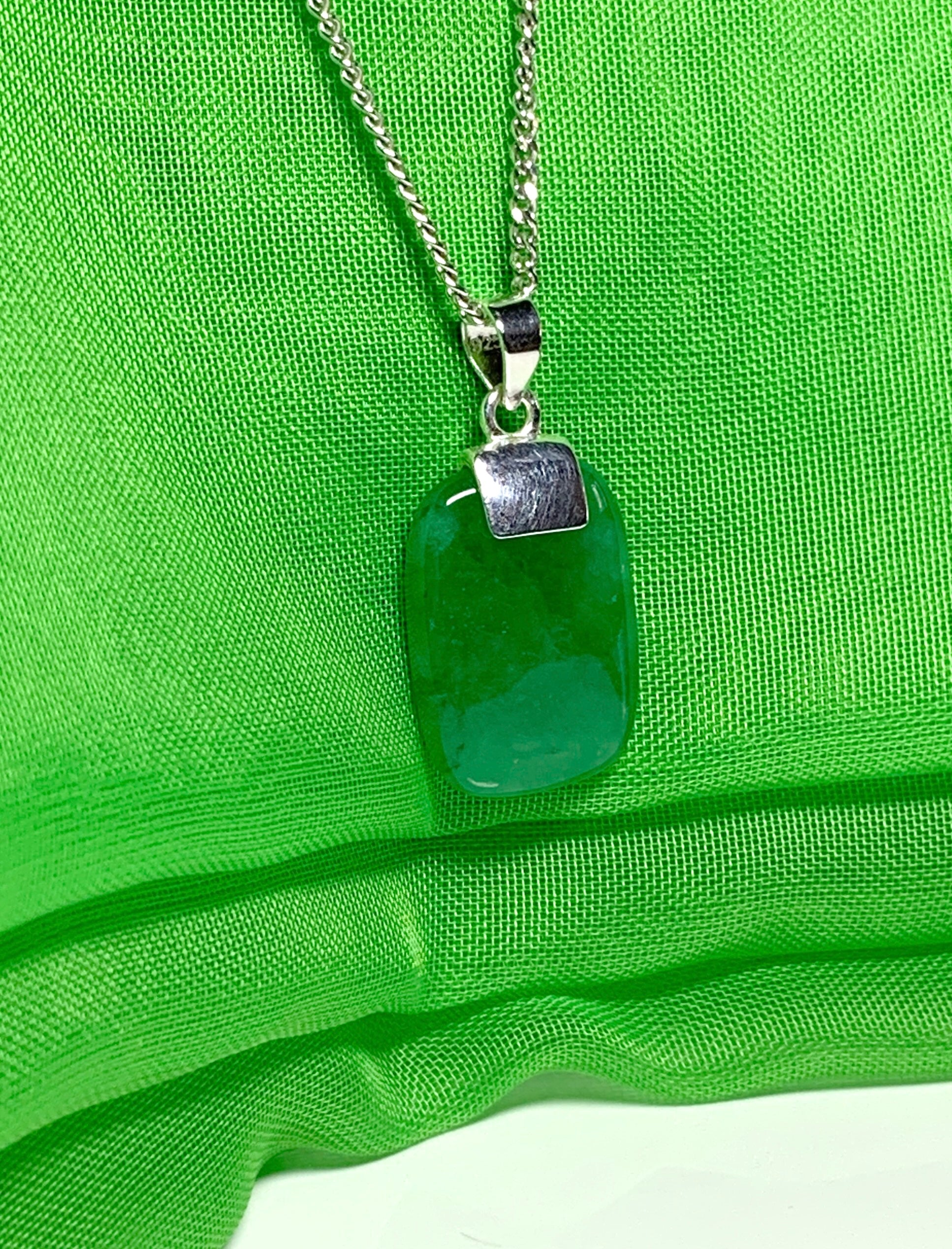 A necklace pendant having a real green jade sterling silver cushion shaped