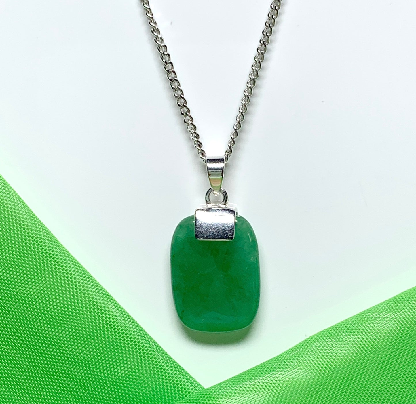 A necklace pendant having a real green jade sterling silver cushion shaped