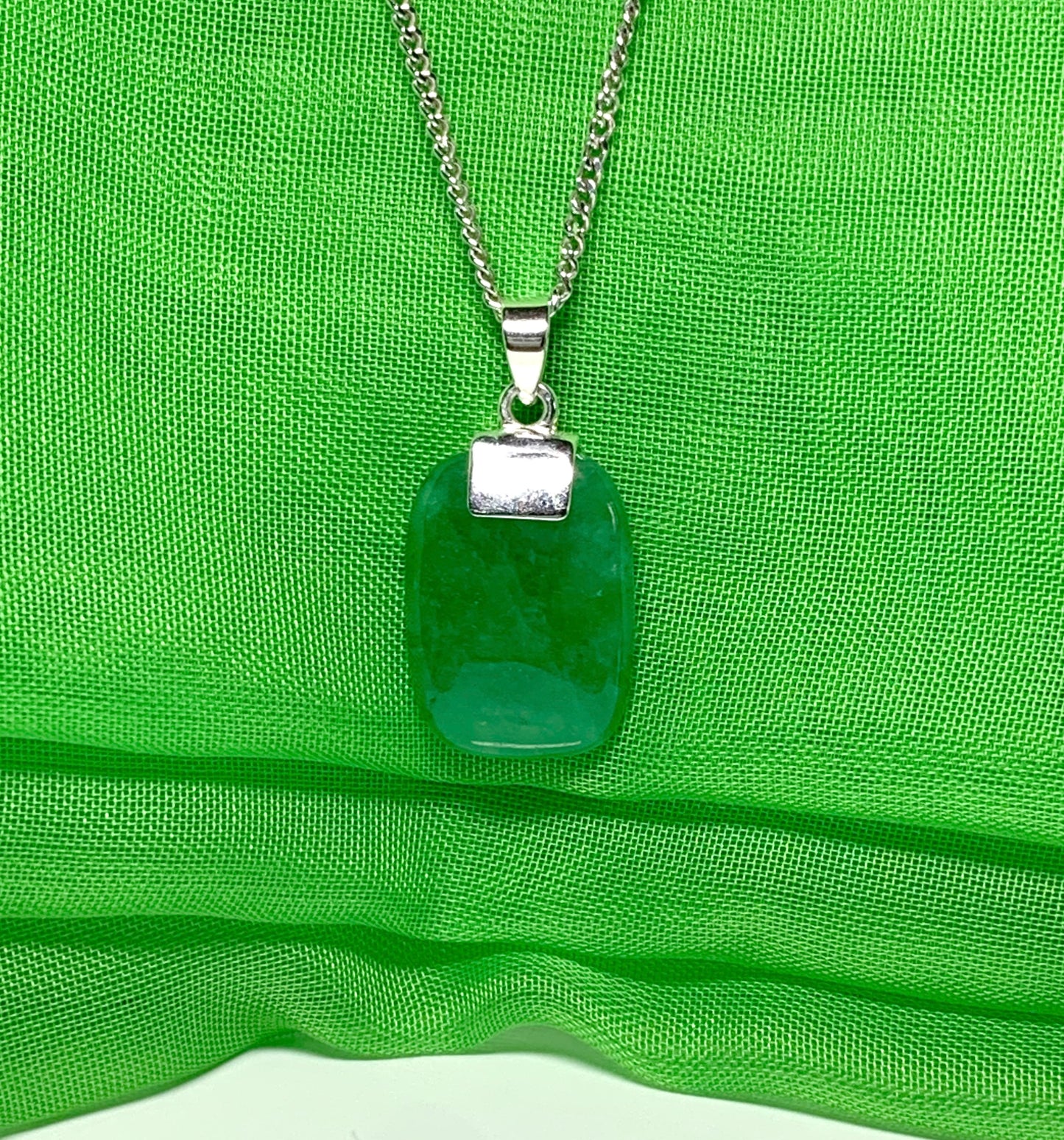 A necklace pendant having a real green jade sterling silver cushion shaped