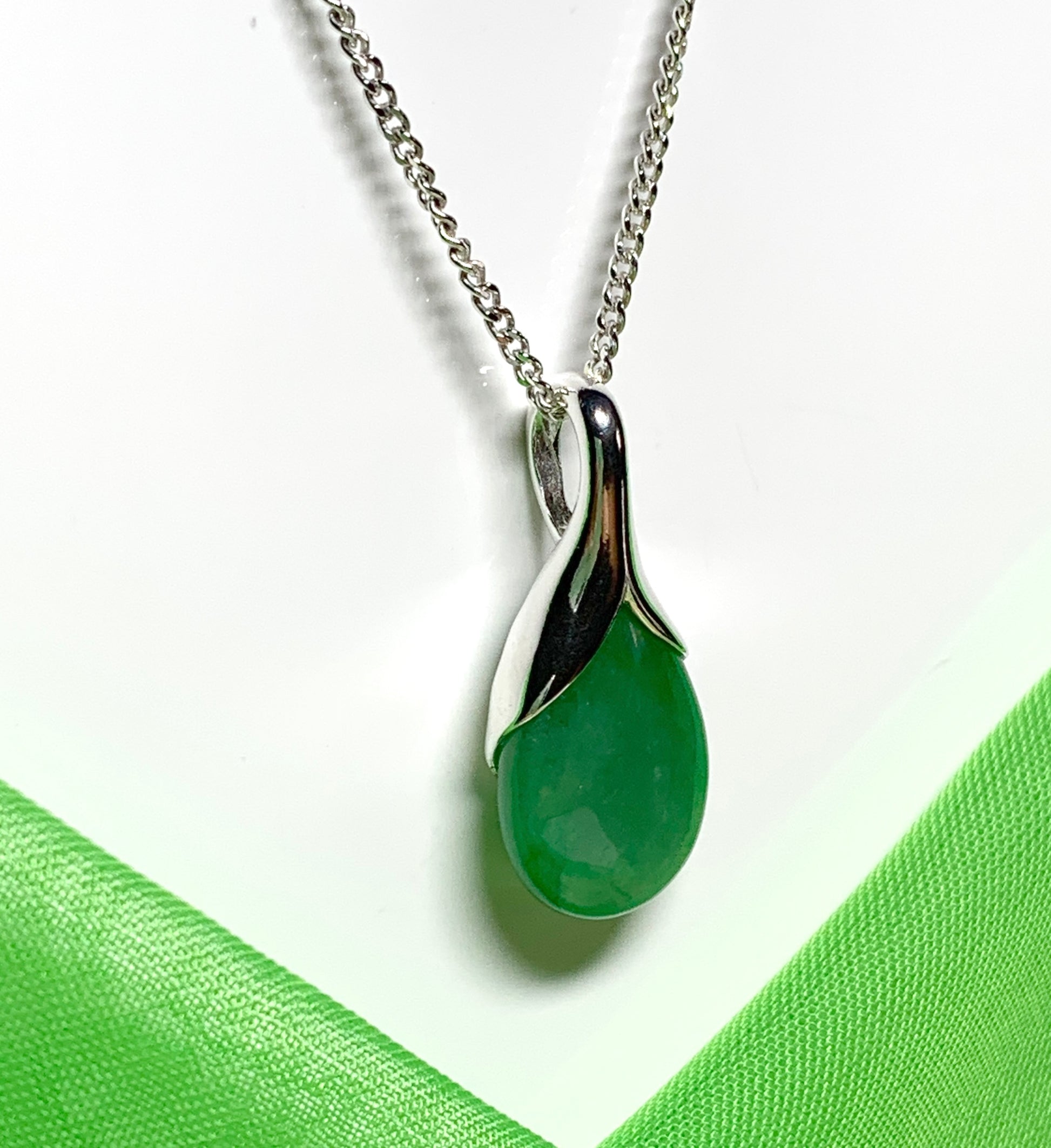 A real green jade pendant necklace in a teardrop shaped or pear shape