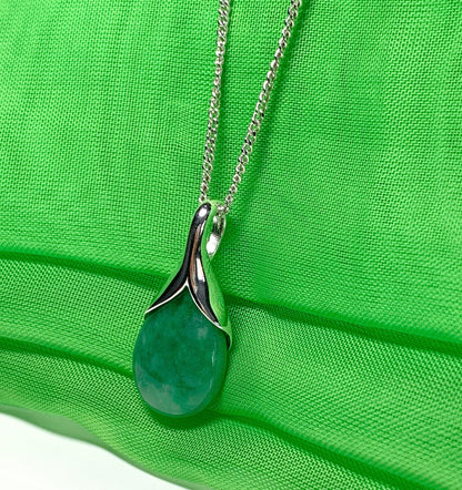 A real green jade pendant necklace in a teardrop shaped or pear shaped