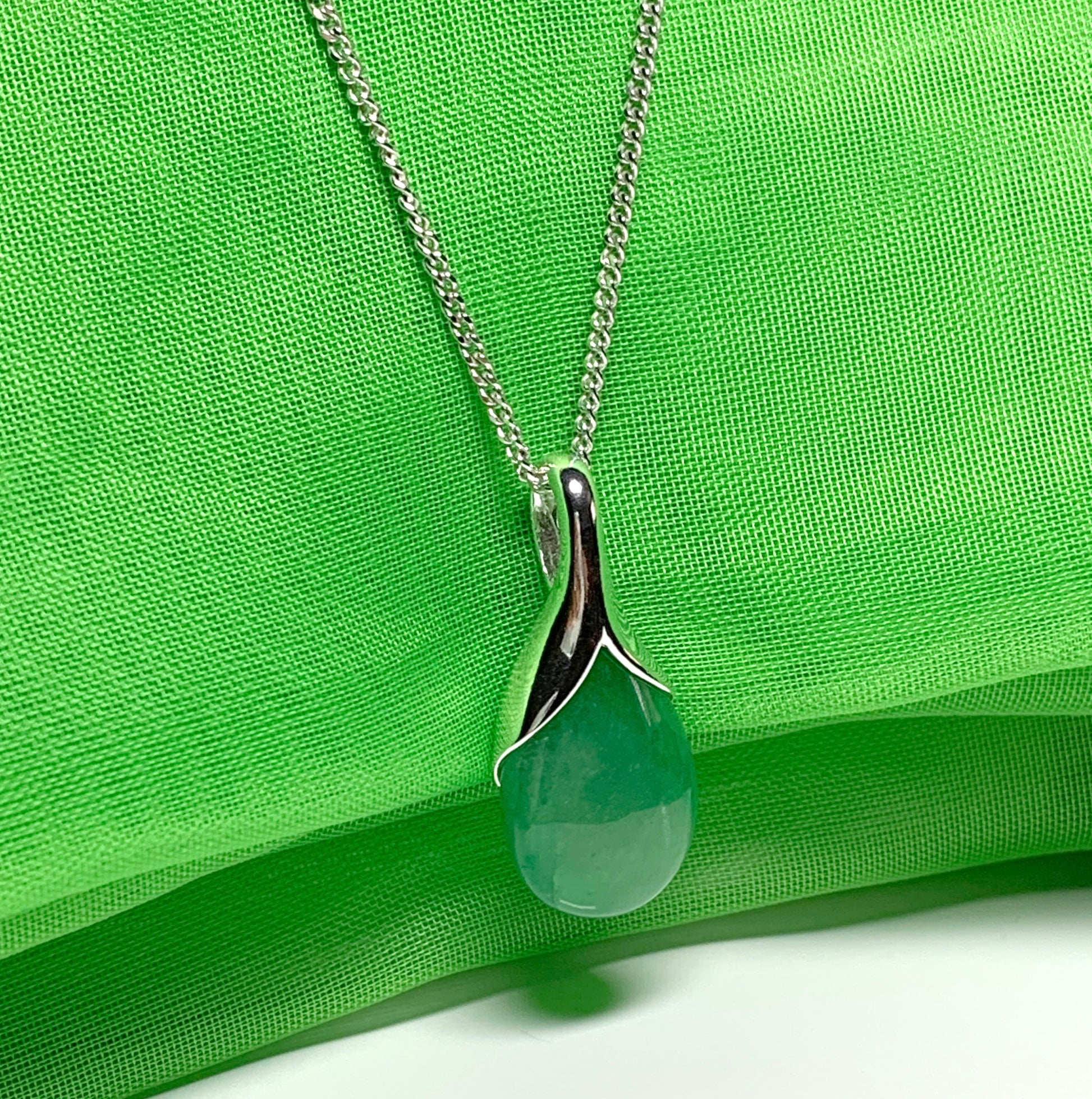 A real green jade pendant necklace in a teardrop shaped or pear shape