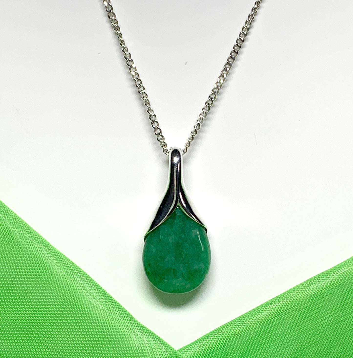 A real green jade pendant necklace in a teardrop shaped or pear shaped