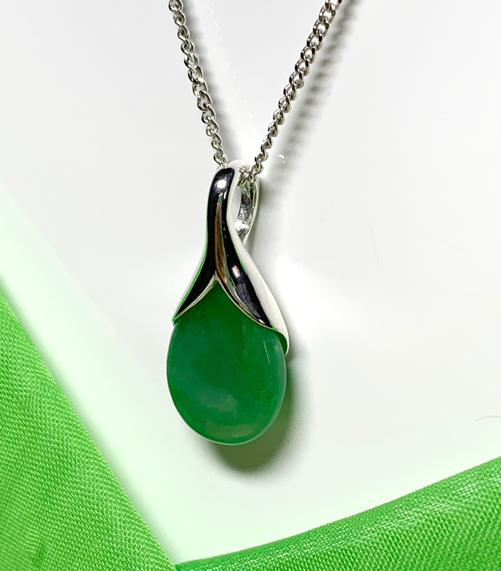 A real green jade pendant necklace in a teardrop shaped or pear shape