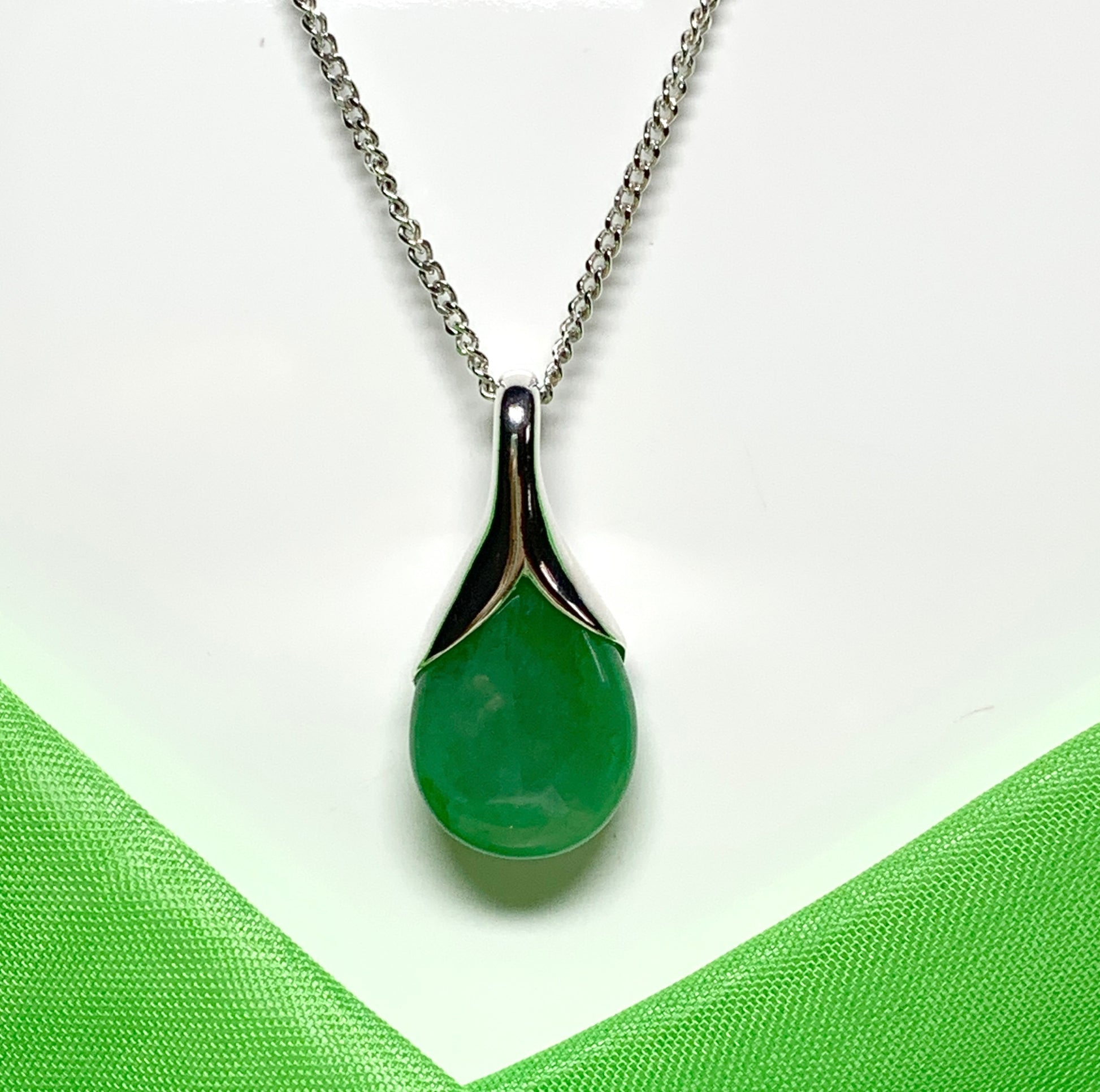 A real green jade pendant necklace in a teardrop shaped or pear shape