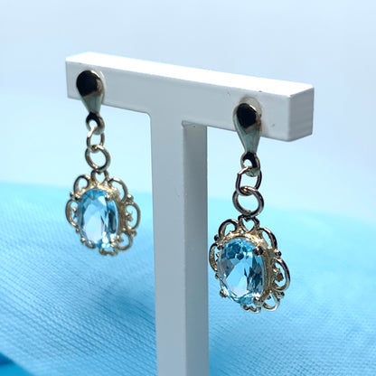 Blue topaz yellow gold oval shaped fancy scrolled drop earrings