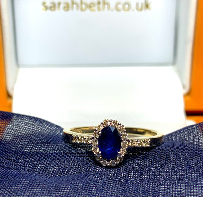 Dark blue sapphire diamond yellow gold oval cluster ring with diamond set shoulders