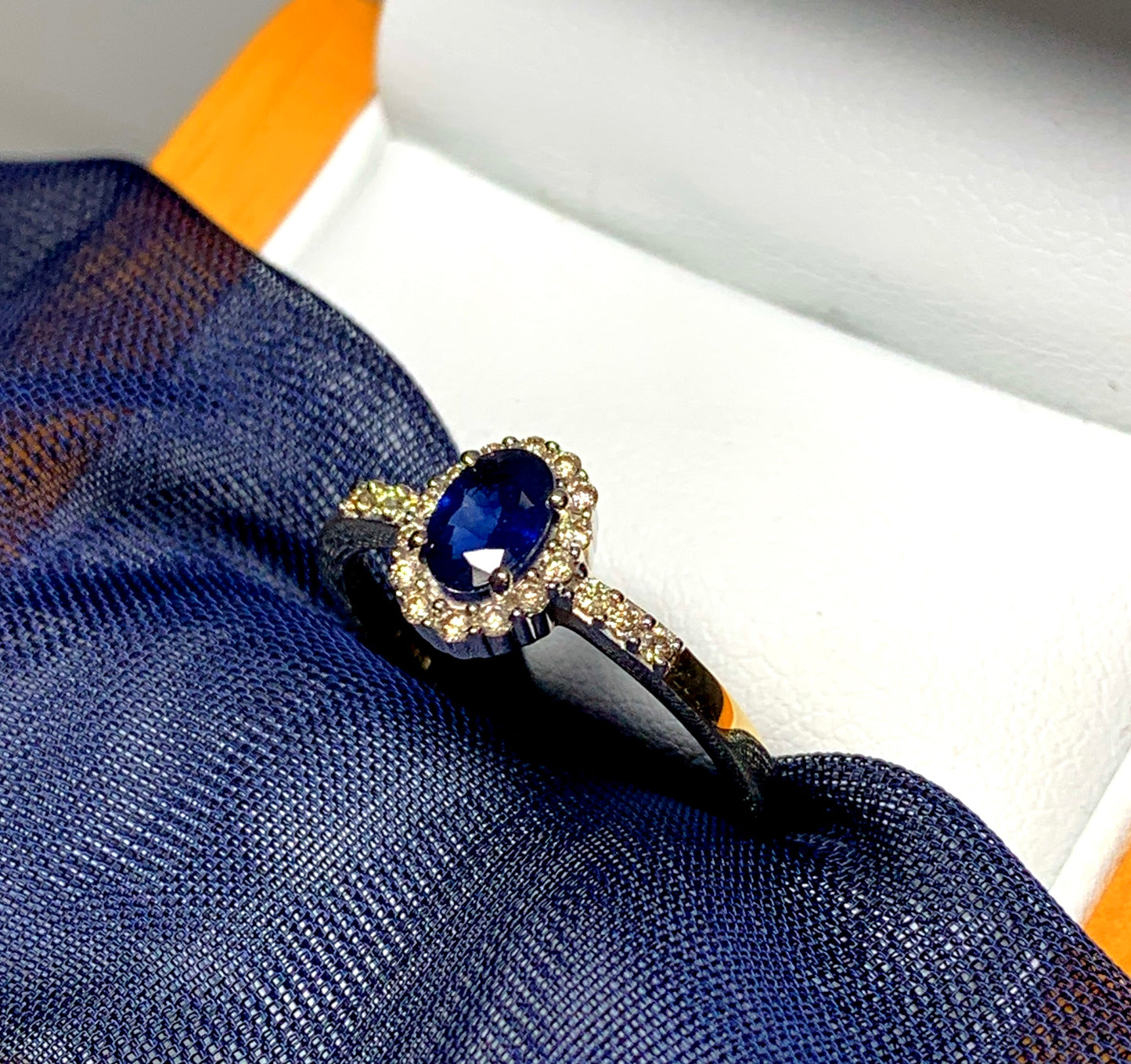 Dark blue sapphire diamond yellow gold oval cluster ring with diamond set shoulders