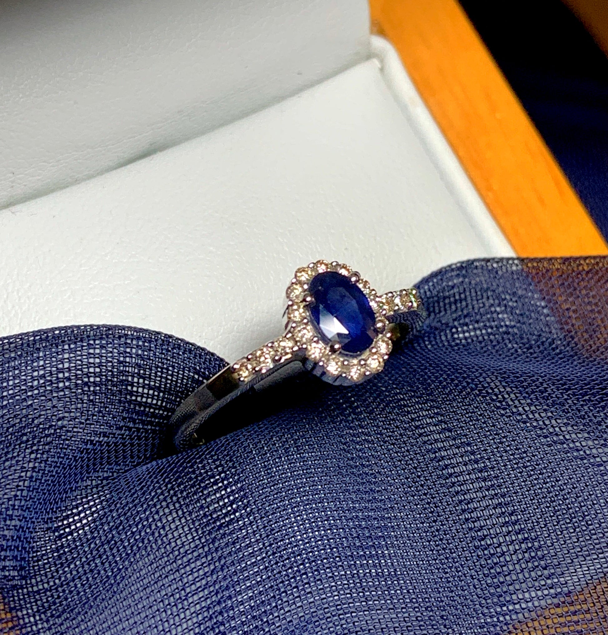 Dark blue sapphire diamond yellow gold oval cluster ring with diamond set shoulders