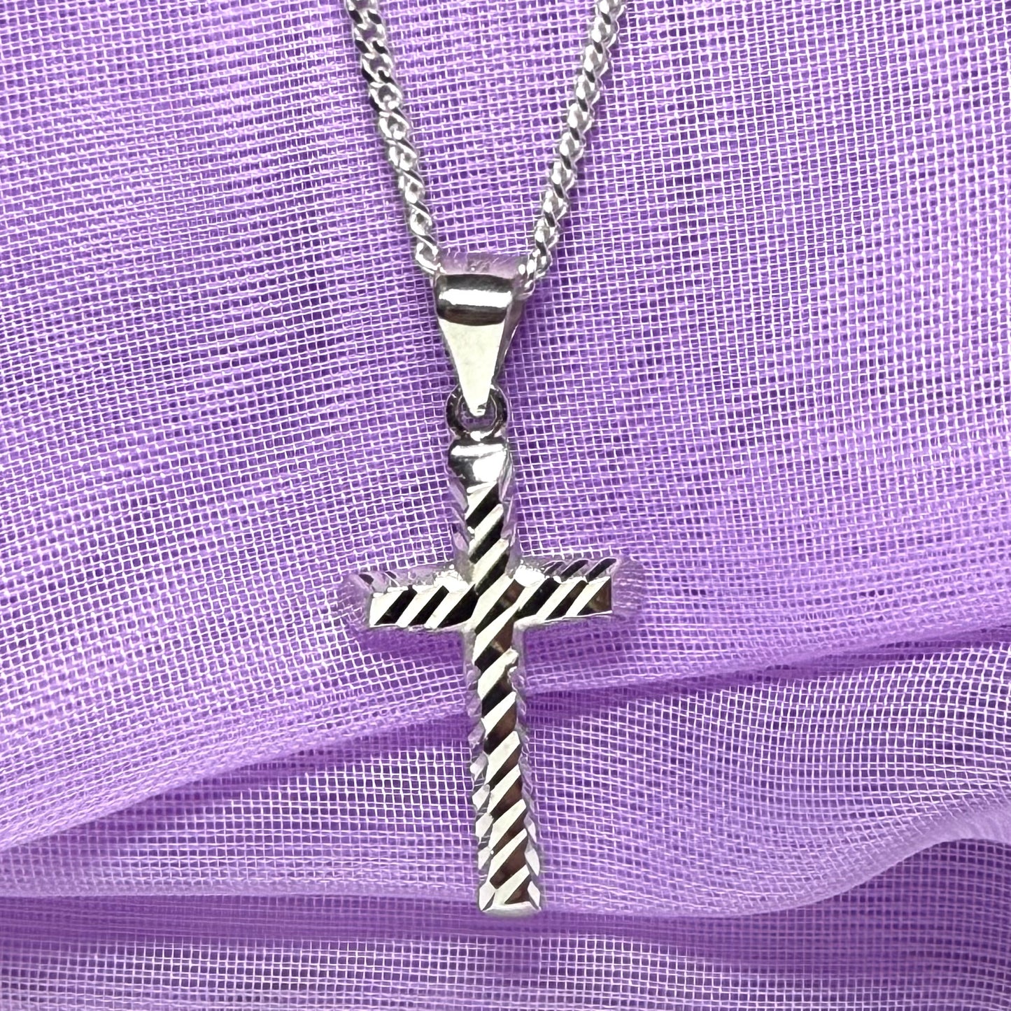 Diamond cut cross patterned sterling silver with a chain Included