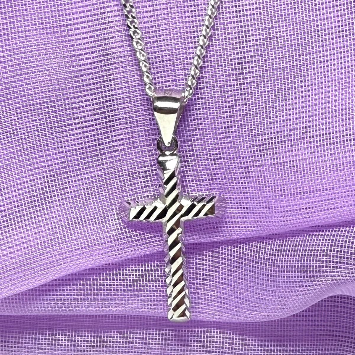 Diamond cut cross patterned sterling silver with a chain Included