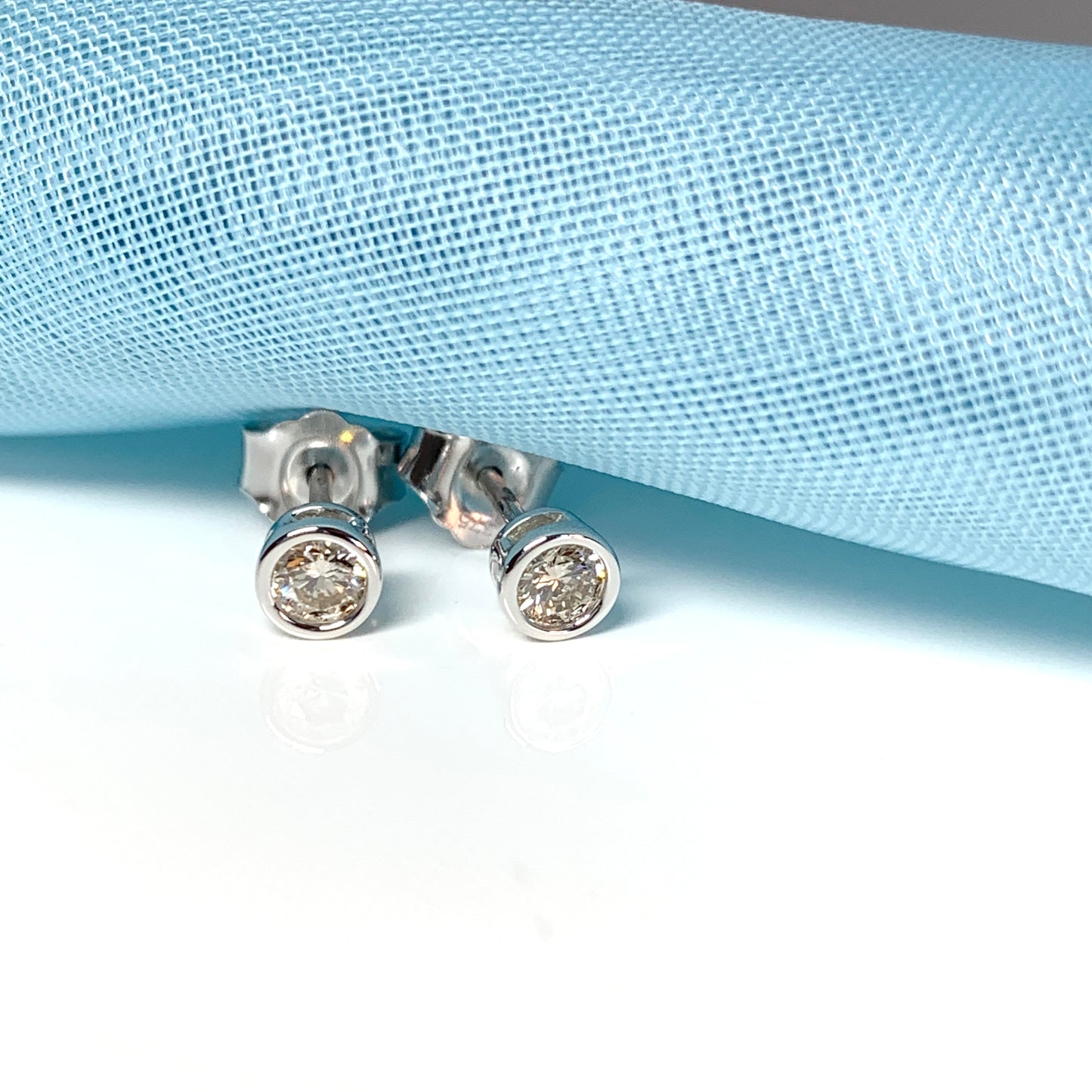 Diamond stud earrings rubbed over single stone smooth setting 25 Points