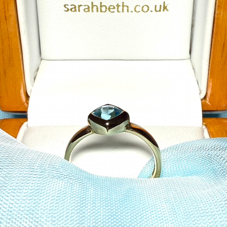 Blue topaz ladies dress ring yellow gold with a smooth rubbed over setting