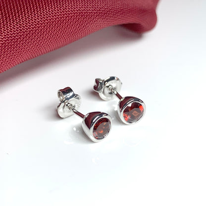 Garnet silver round stud earrings smooth rubbed over setting