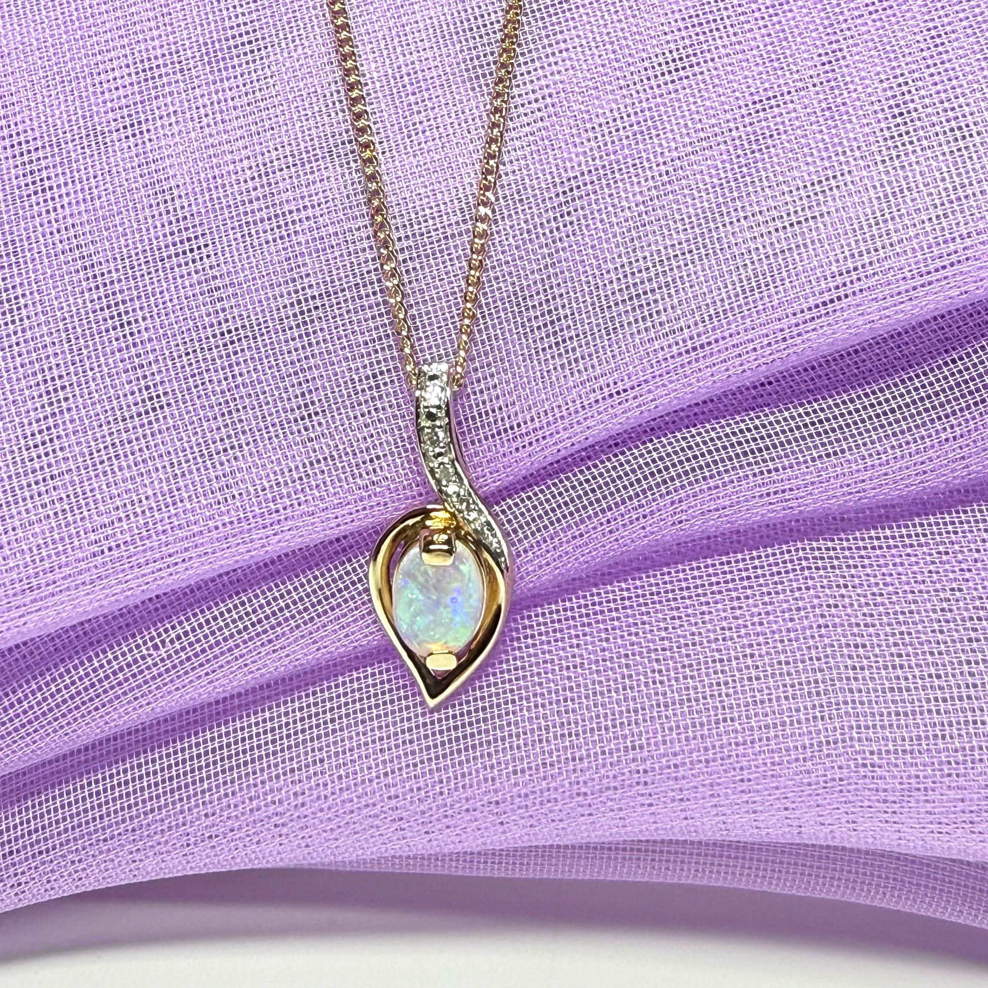 Necklace with a heart-shaped opal pendant on a purple fabric background