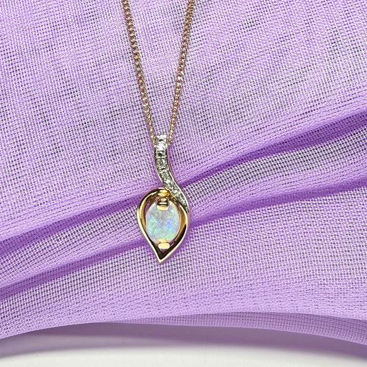 Necklace with a heart-shaped opal pendant on a purple fabric background