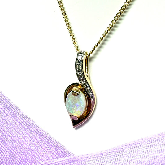 Gold real opal and real diamond necklace pendant oval shaped in a swirl design