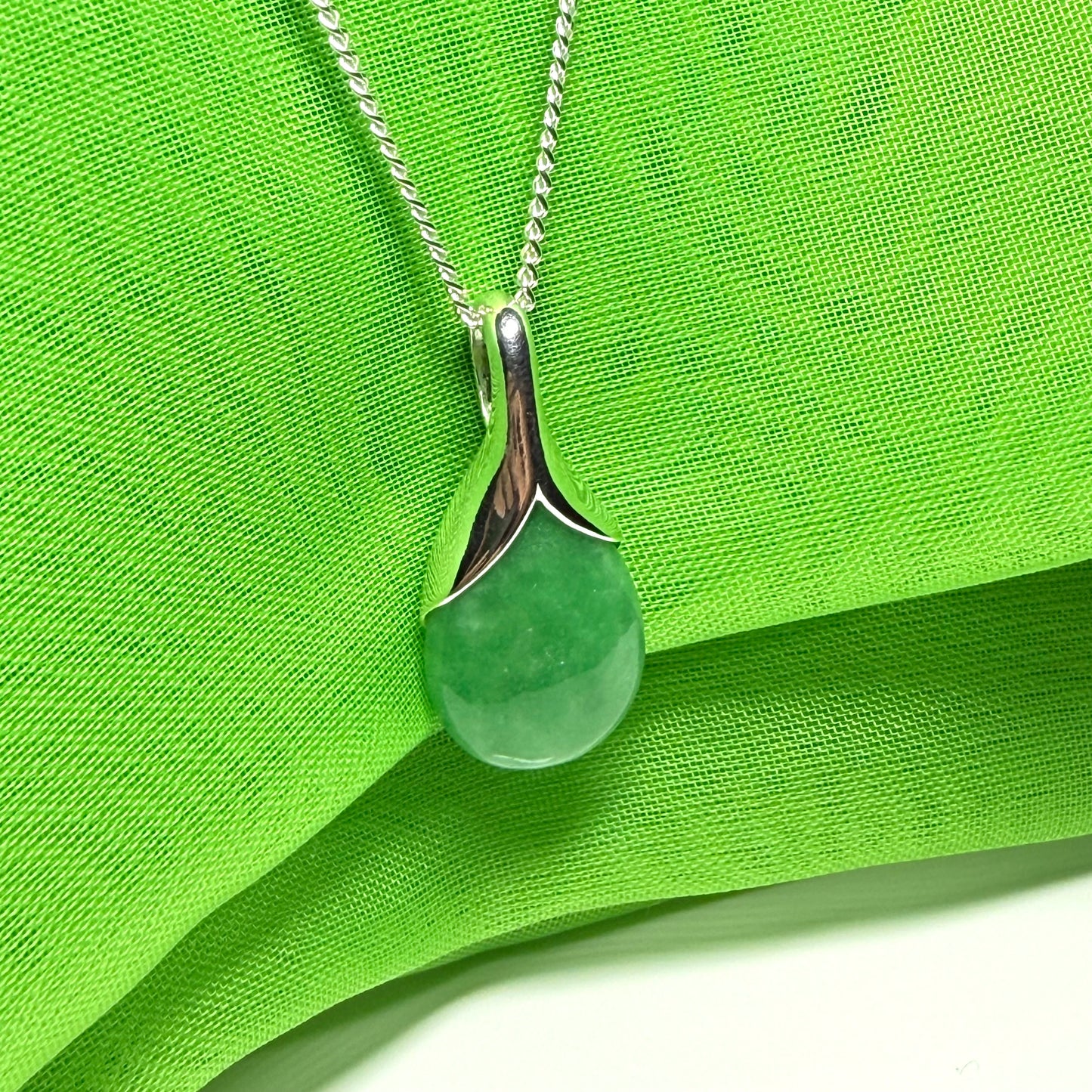 A gorgeous real green jade necklace in a tear drop or pear shaped with a chain as well