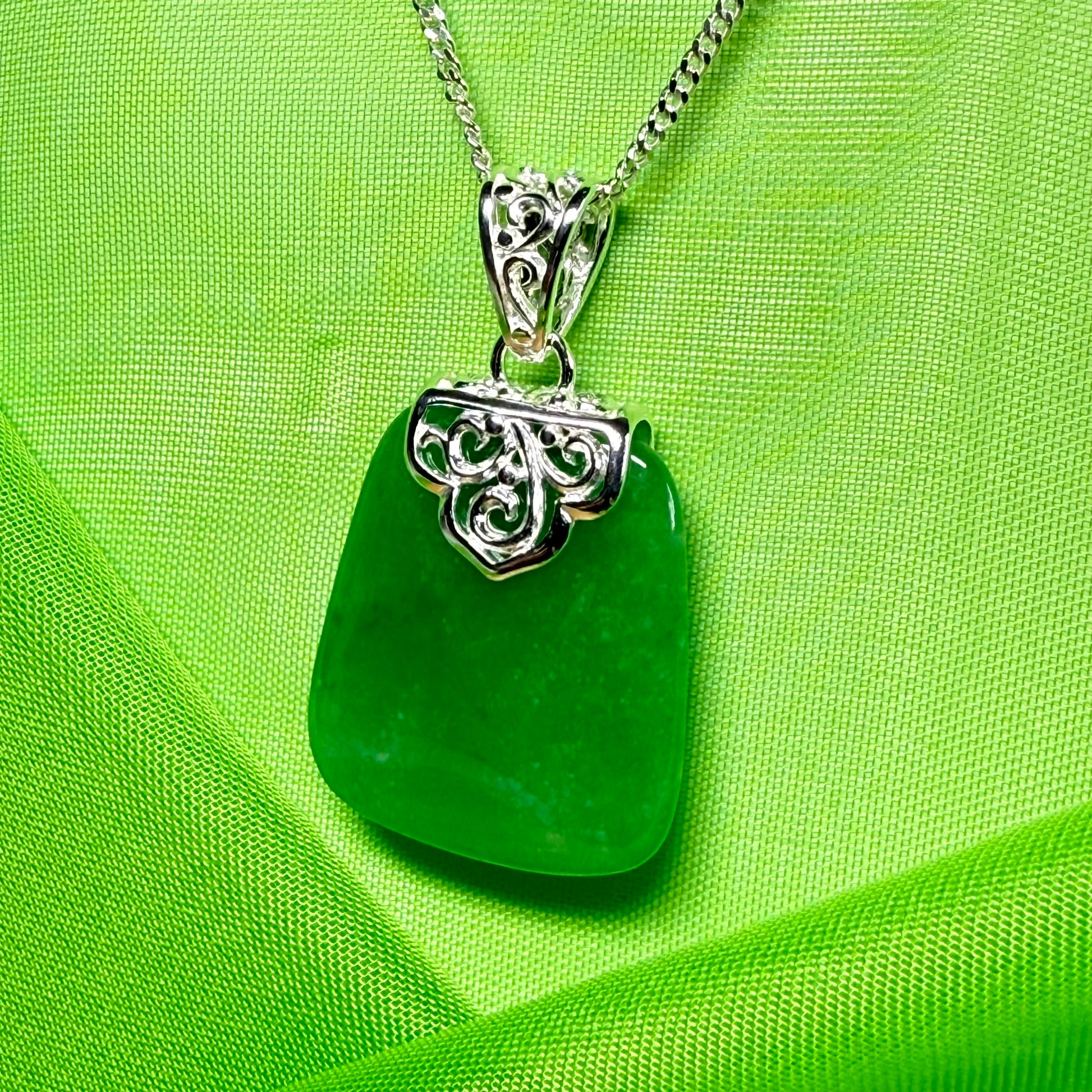 Green pendant necklace on a green fabric background