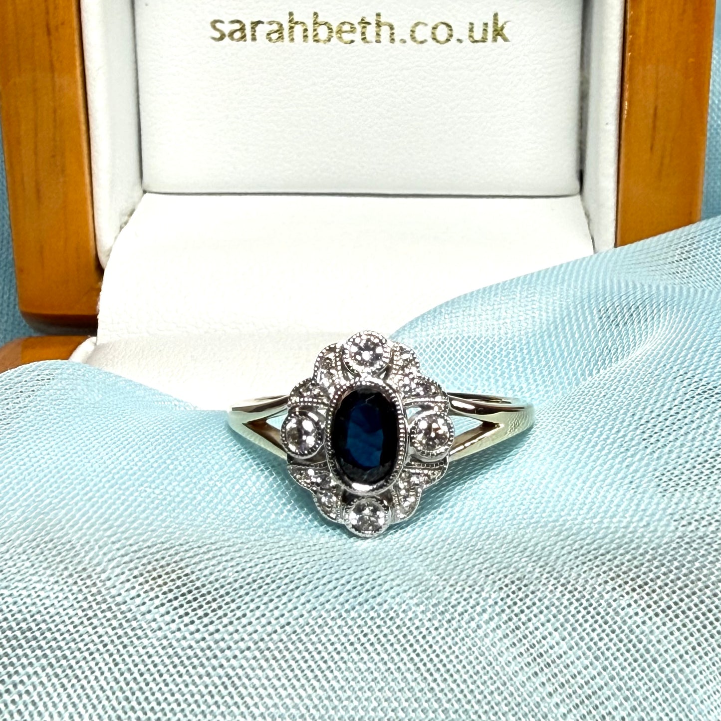 Dark blue sapphire and diamond yellow gold cluster ring