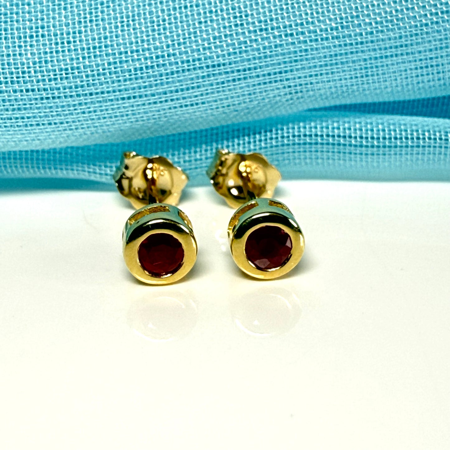 Pair of real red ruby earrings round yellow gold stud smooth rubbed over setting