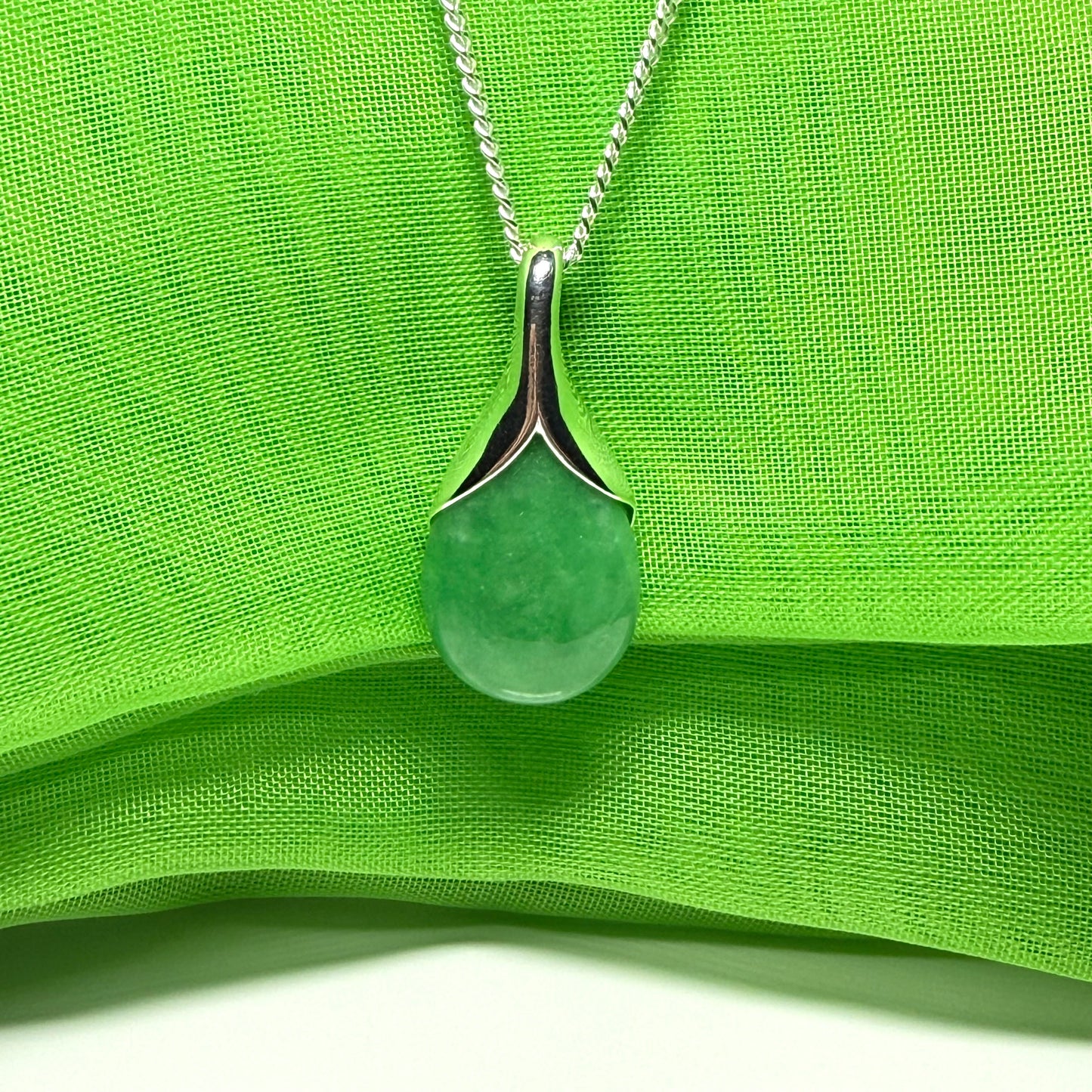 A gorgeous real green jade necklace in a tear drop or pear shaped with a chain as well