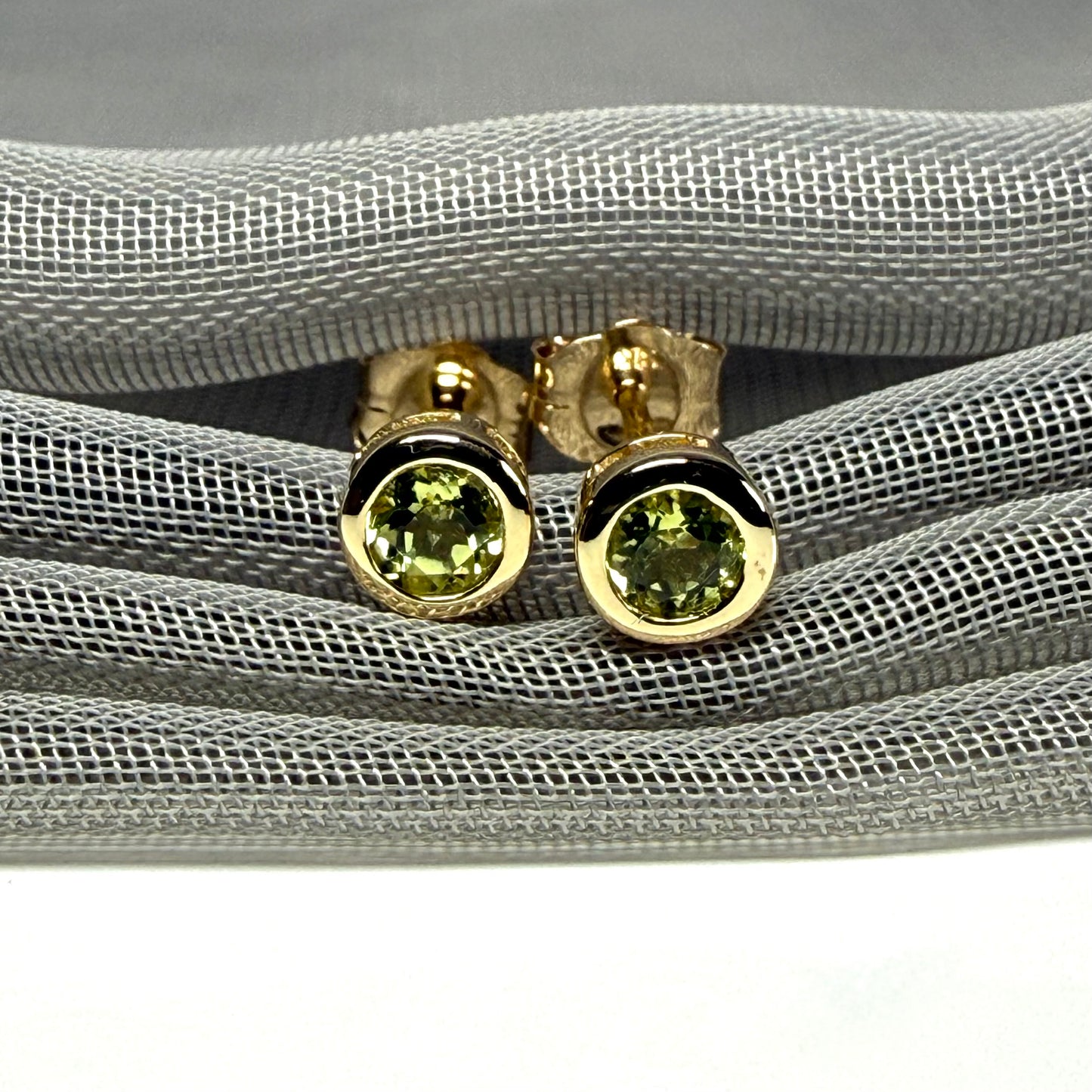 Pair of real green peridot earrings round yellow gold stud smooth rubbed over setting