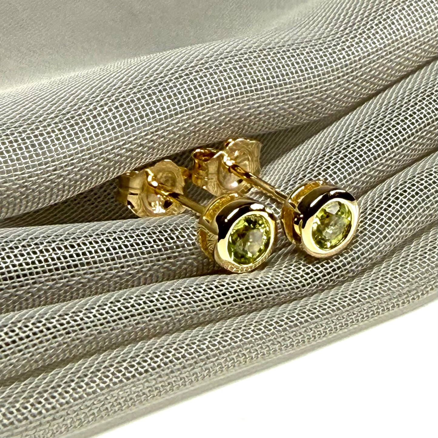 Pair of real green peridot earrings round yellow gold stud smooth rubbed over setting