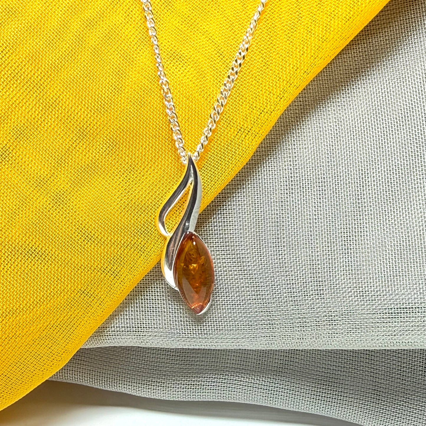 A sterling silver real amber marquise shape necklace open pierced pendant with a chain