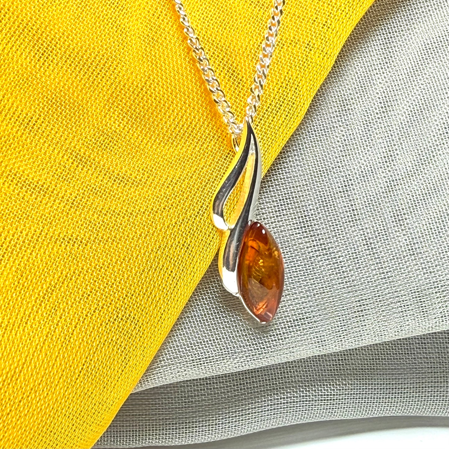 A sterling silver real amber marquise shape necklace open pierced pendant with a chain