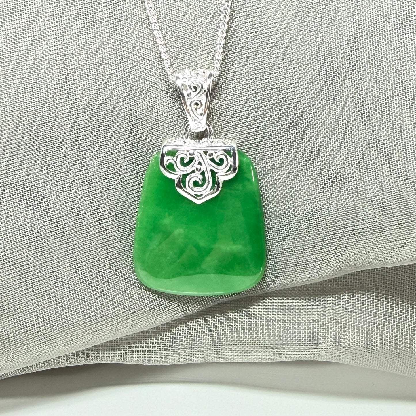 A real green jade necklace large pendant that is cushion in shape