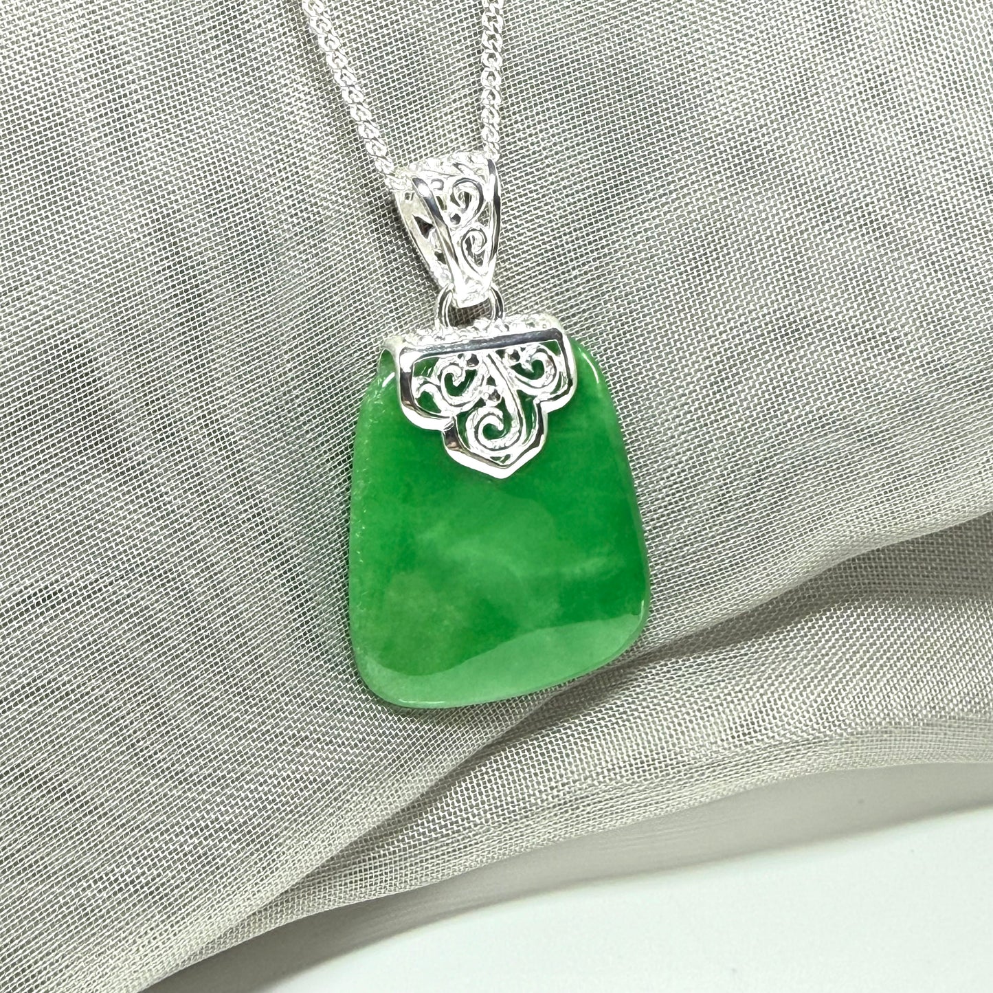 A real green jade necklace large pendant that is cushion in shape