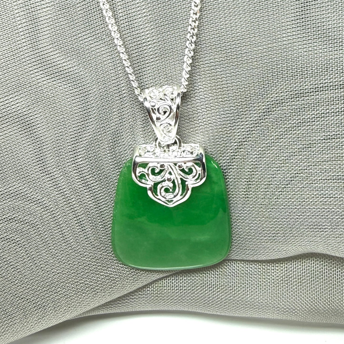A real green jade necklace large pendant that is cushion in shape