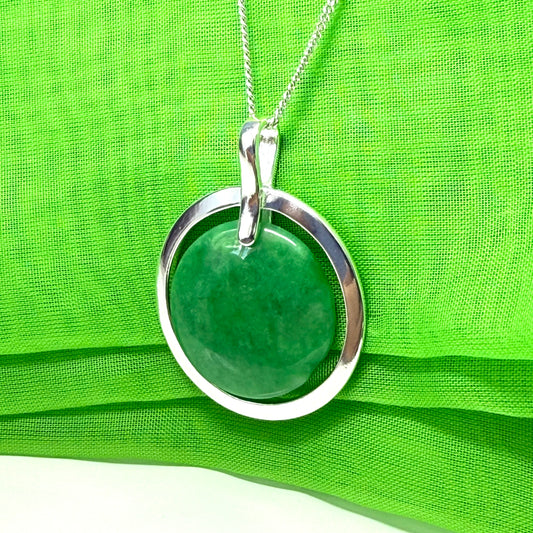 Green pendant necklace on a green fabric background