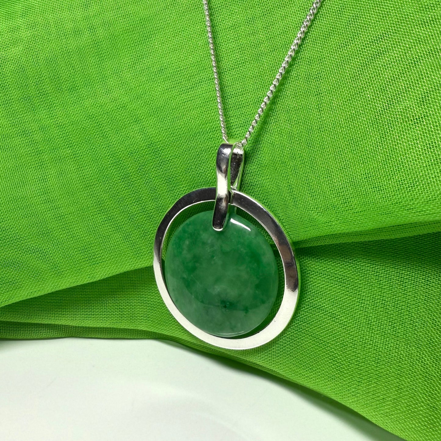 Necklace with a green pendant on a green fabric background
