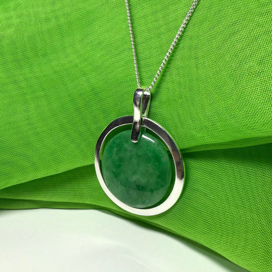 Necklace with a green pendant on a green fabric background