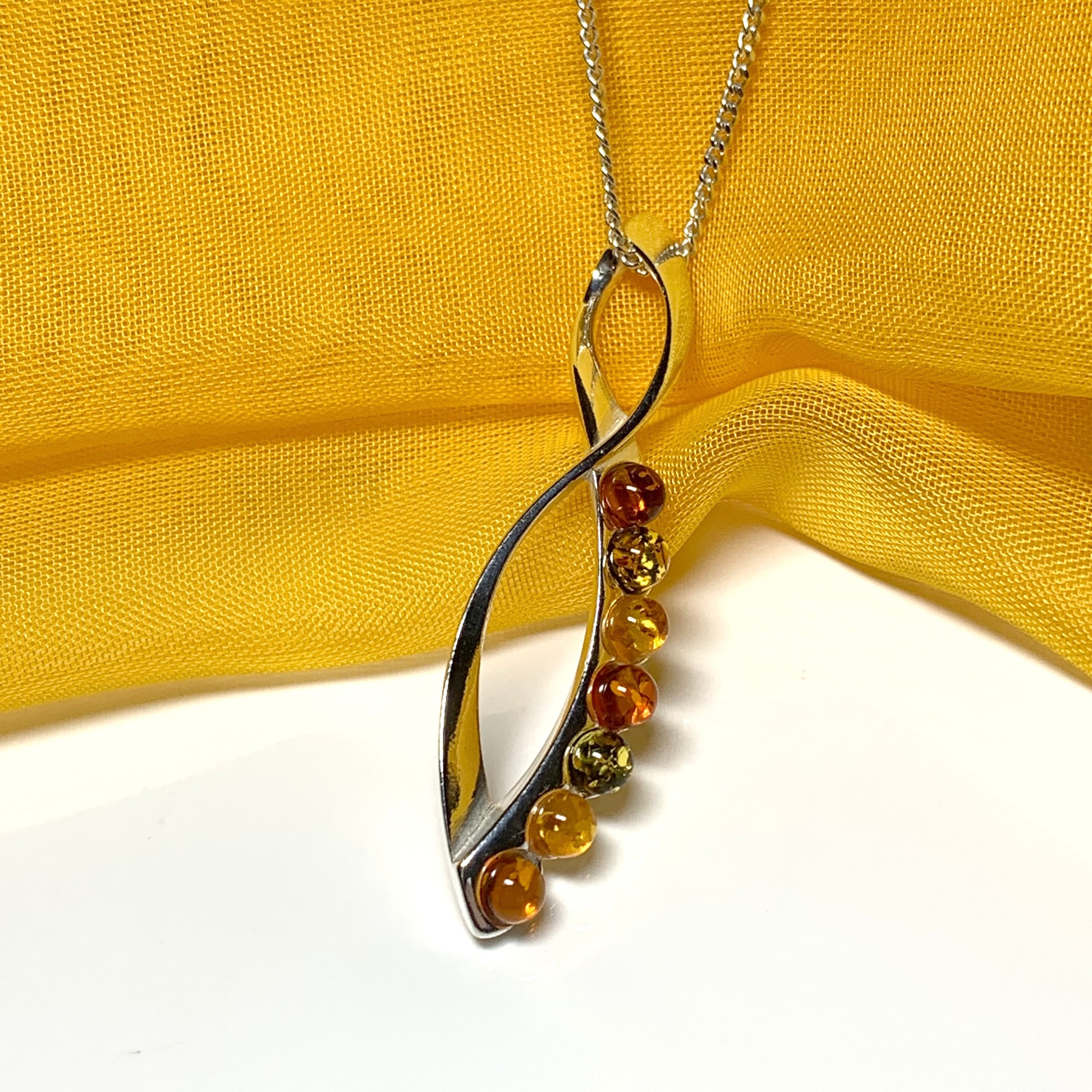 Multi colour amber figure of eight drop sterling silver necklace