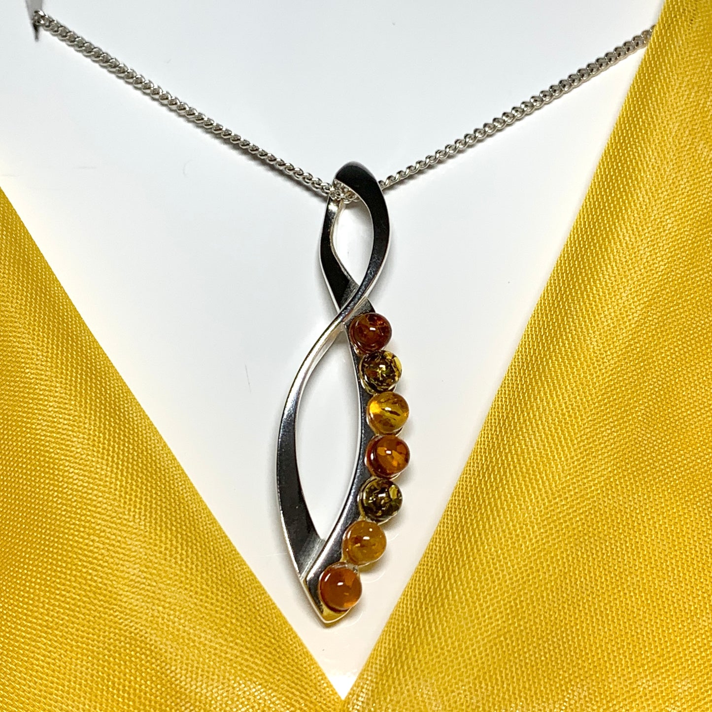 Multi colour amber figure of eight drop sterling silver necklace