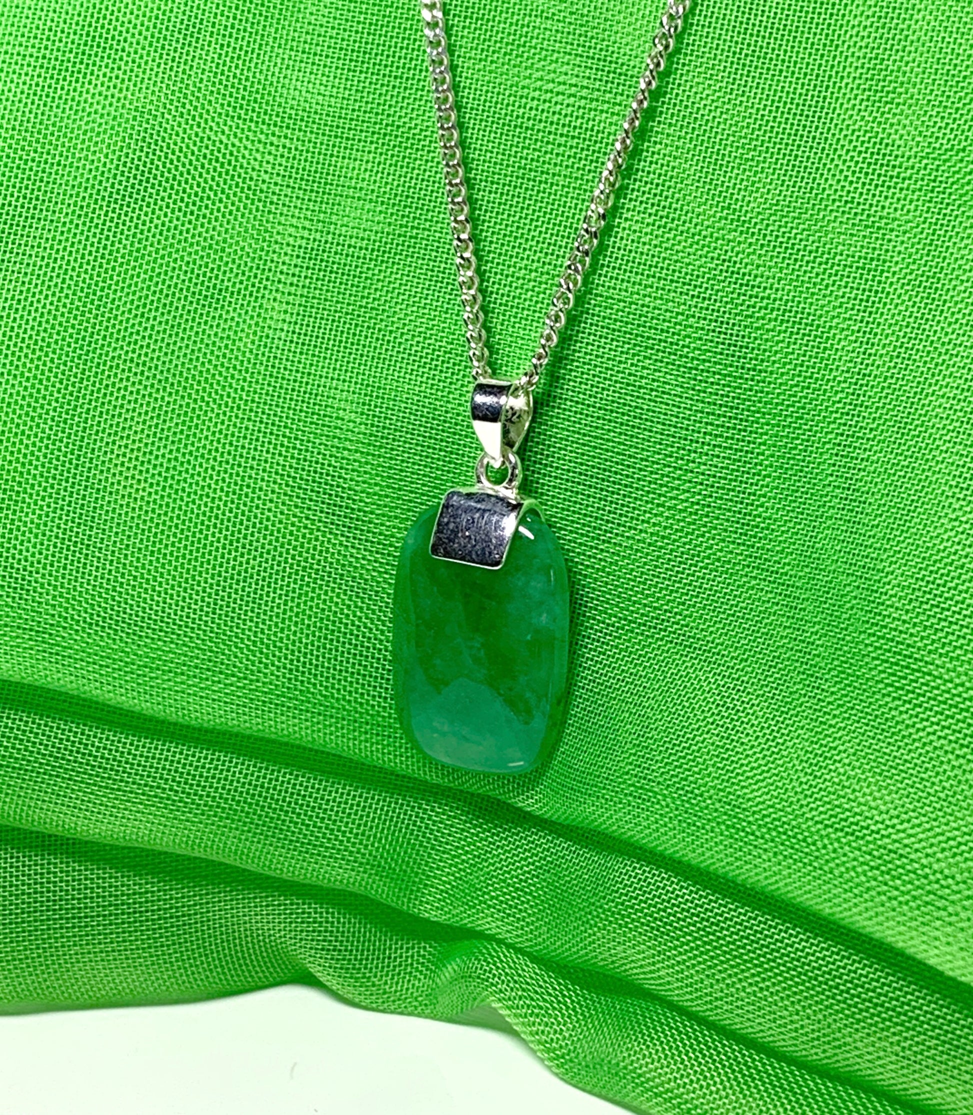 A necklace pendant having a real green jade sterling silver cushion shaped