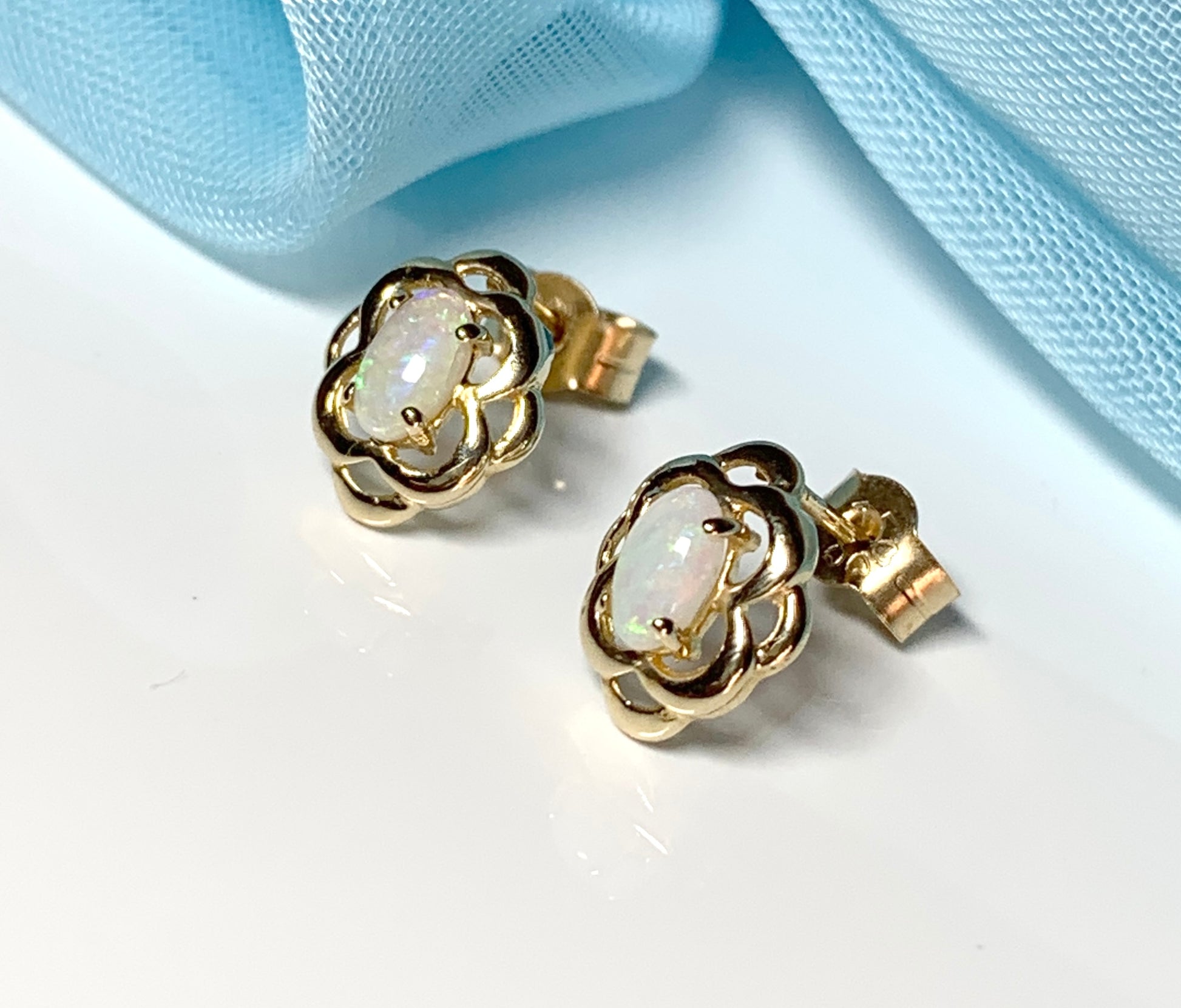 Opal yellow gold emerald stud earrings oval shaped scroll design