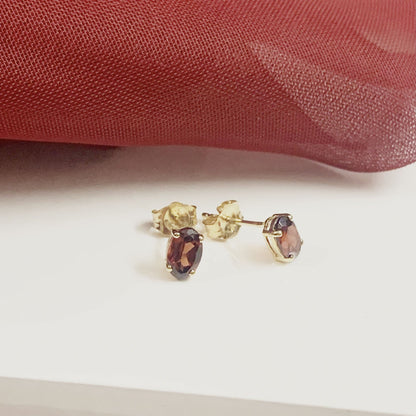 Oval garnet yellow gold stud earrings