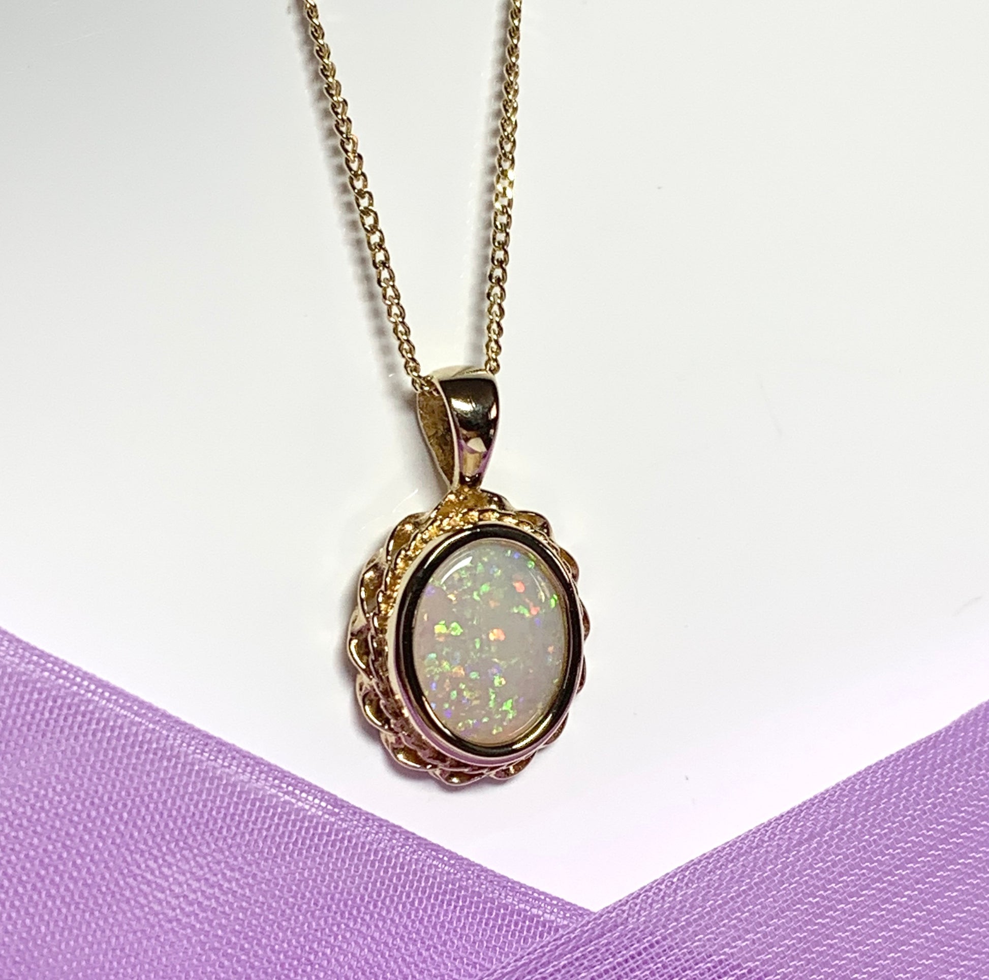 Oval real opal yellow gold necklace with a roped edge