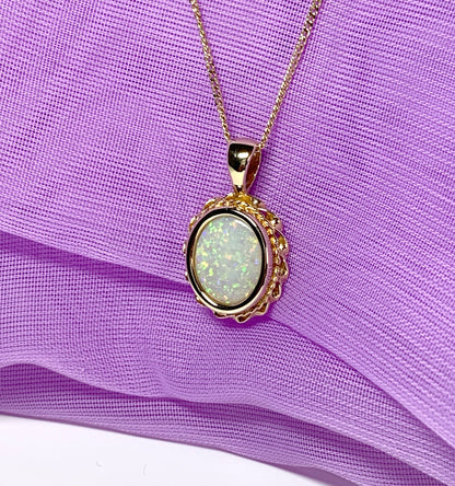 Oval real opal yellow gold necklace with a roped edge